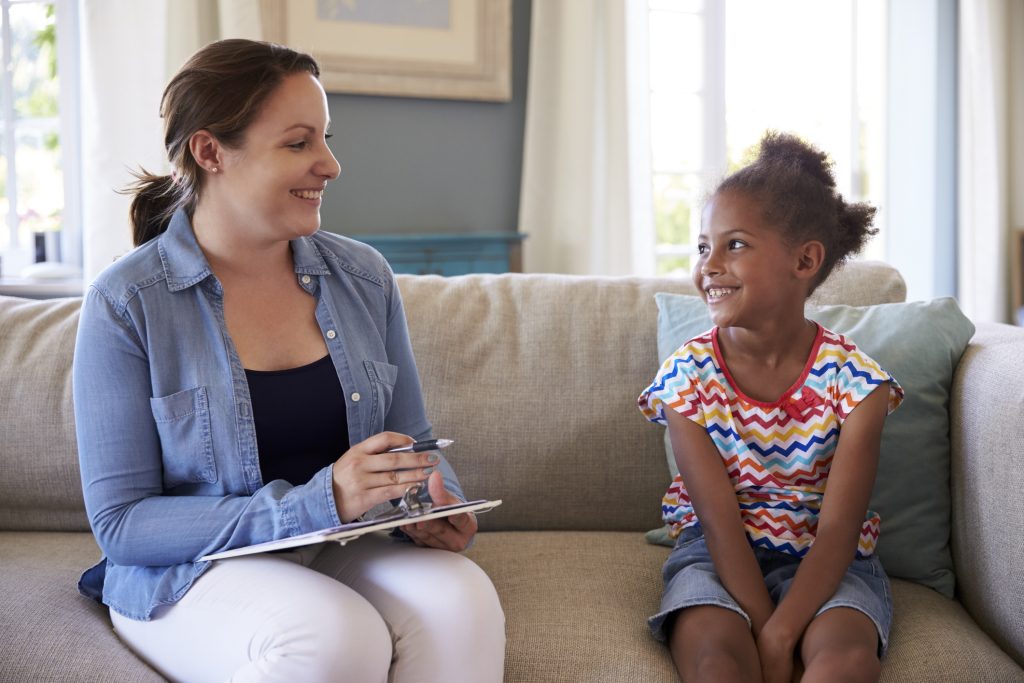 a counselor smiles toward a young girl